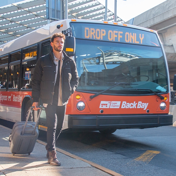 Man walking beside an orange bus