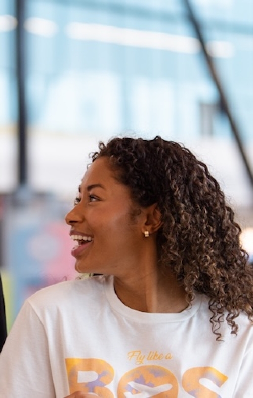 Man and Woman walking through the terminal with BOS apparel on