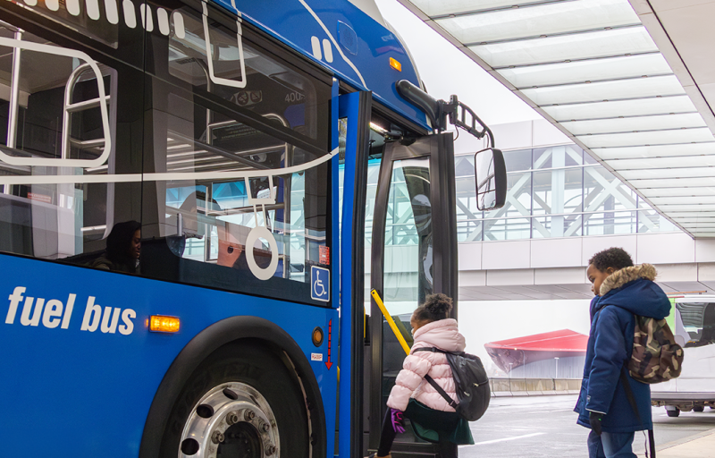 Family getting on on airport shuttle bus at Boston Logan