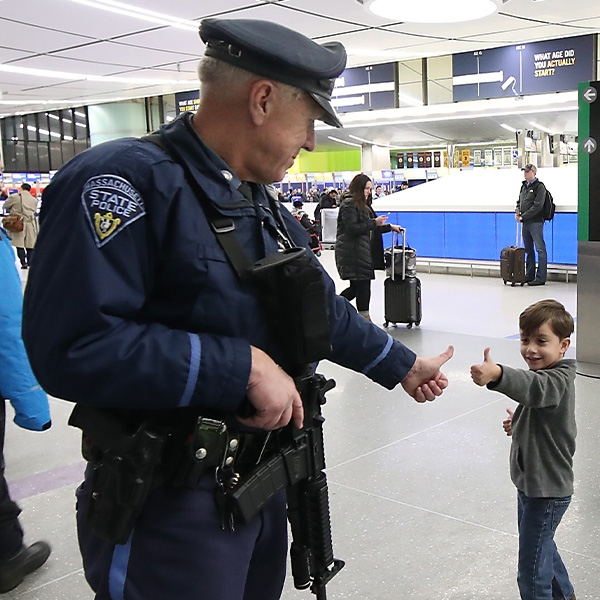 Police officer gives thumbs up to a child nearby.