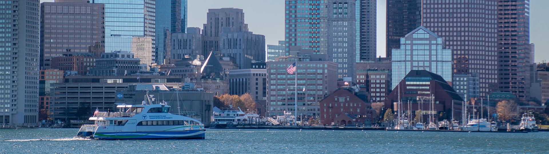 Ferry in water with city skyline in background