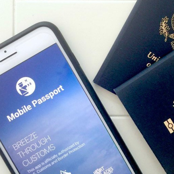 Picture of a phone with the Mobile Passport app open next to physical U.S. passports