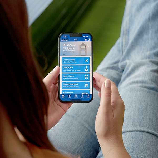 Women holding phone with screen showing the FlyLogan app