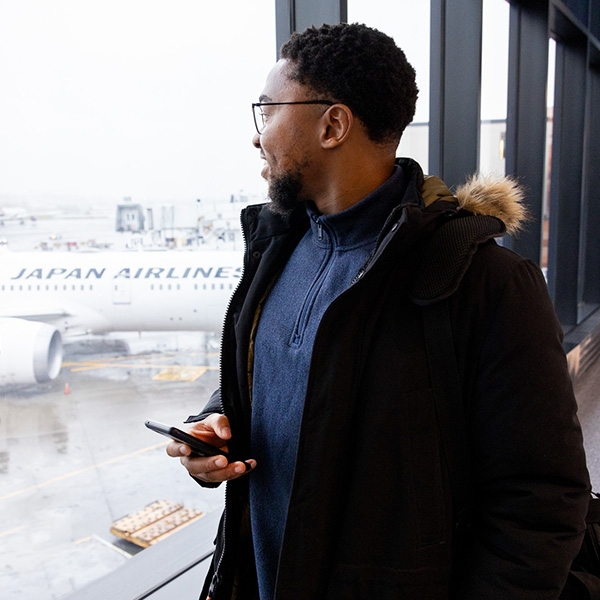 Man holding phone while looking out window