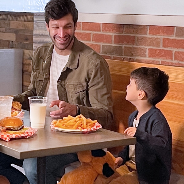 Man and little boy eating fries
