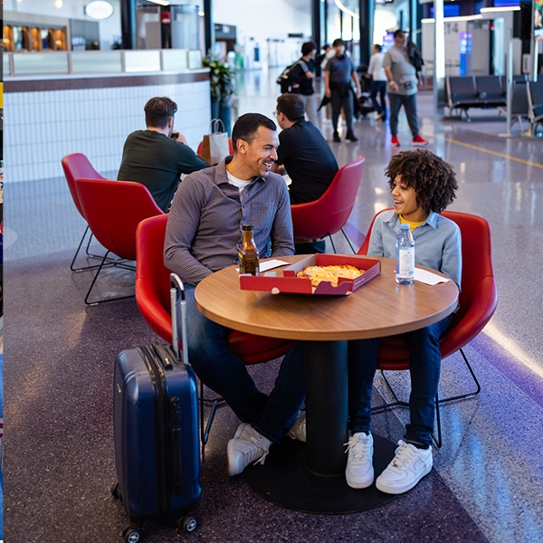 Father and son enjoy food at Boston Logan's Terminal E