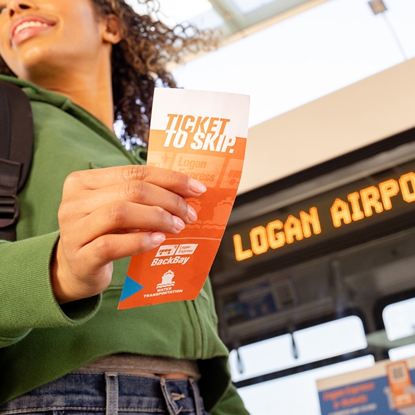 Woman holds a Ticket to Skip getting off the bus at Boston Logan