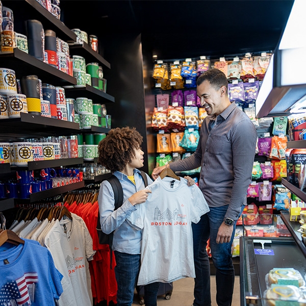 Father and son shopping for t shirts at Hudson in Boston Logan
