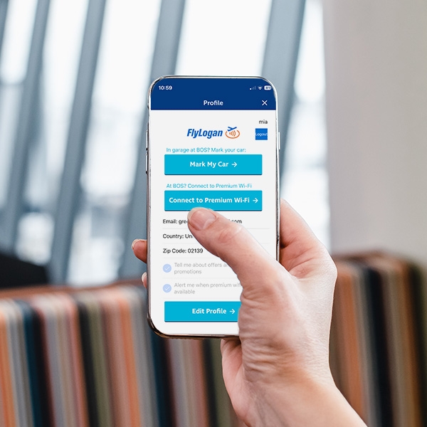 A passenger holding up their phone while using the FlyLogan app for enhanced Wifi
