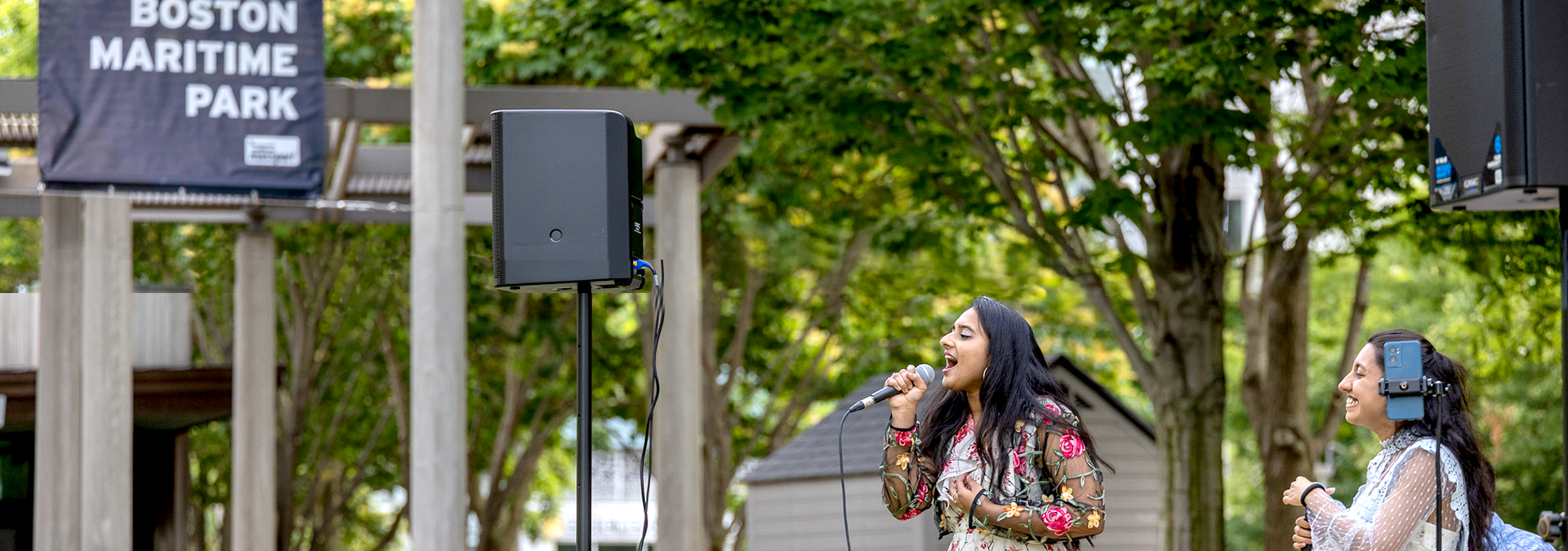Two women singing in the South Boston Maritime Park