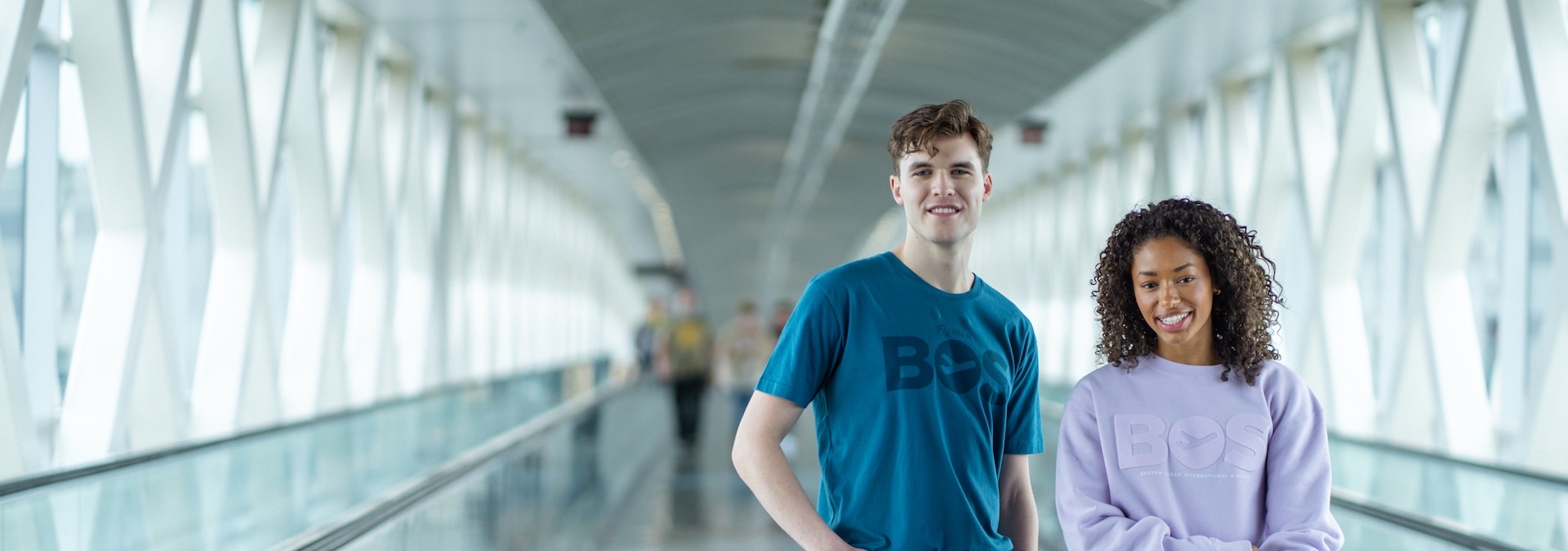 Man and Woman standing in walkway with BOS apparel on