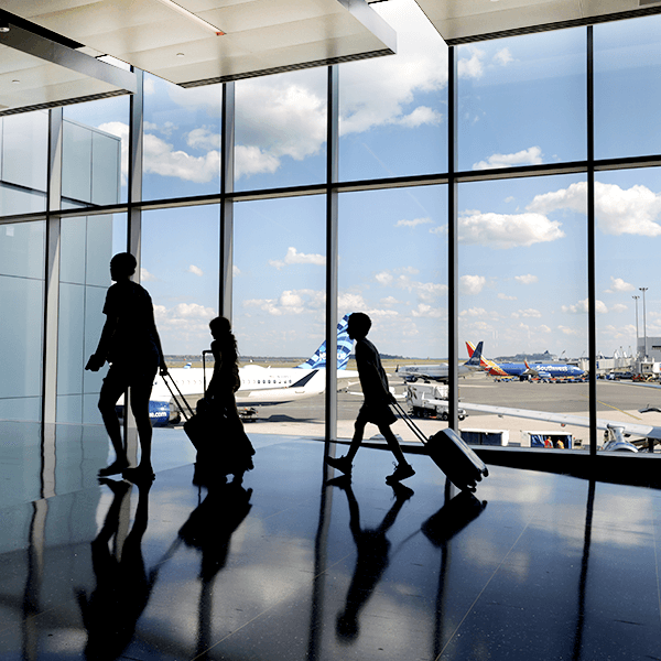Passengers walking in front of windows through Terminal E
