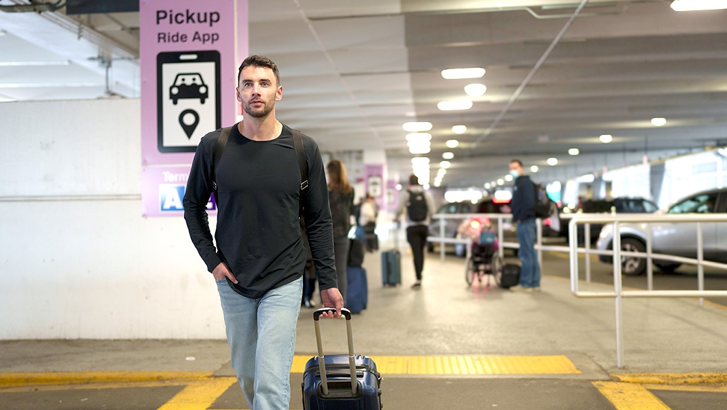 Man walking post ride app pickup sign