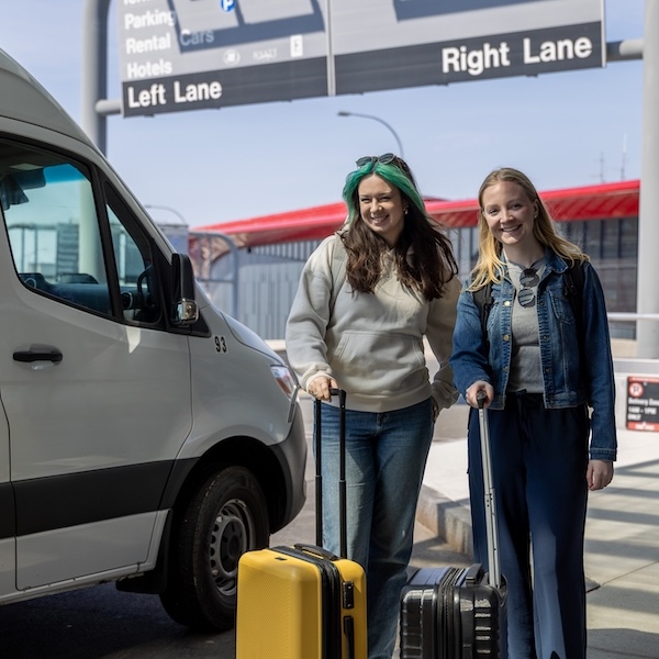Two college students standing in front of shuttle
