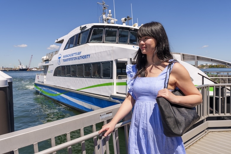 Women standing in front of the water ferry with luggage