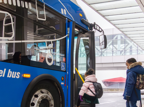 Family getting on on airport shuttle bus at Boston Logan