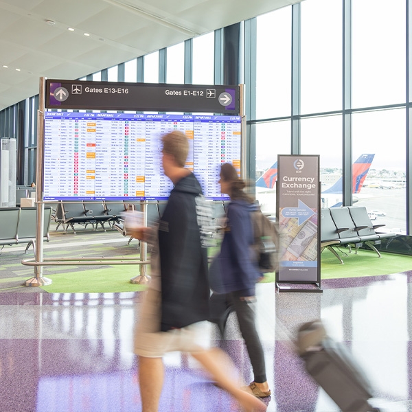 Two people walking through airport terminal