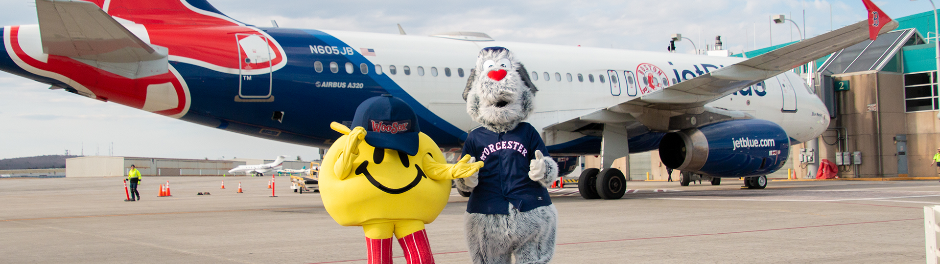 WooSox mascots at the airport with plane in the background